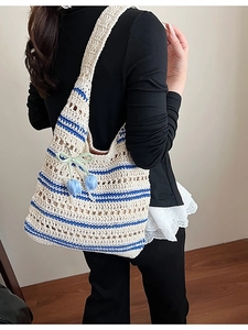Handmade woven straw tote bag with blue stripes and floral charm for beach use