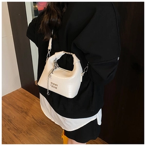 Detail of white crocodile pattern shoulder bag with silver chain and metal handle