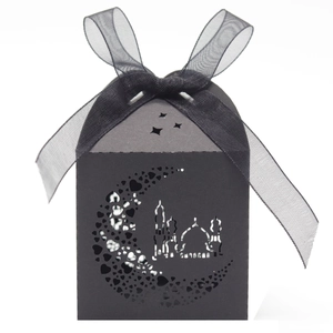 Macro detail of laser-cut black Ramadan moon and mosque pattern on a gift box