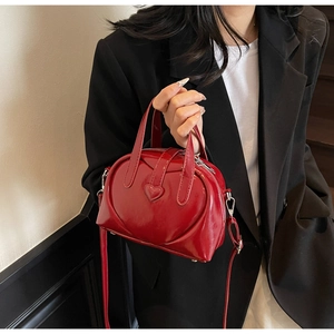 Detail of red glossy Boston bag with heart quilting and adjustable shoulder strap