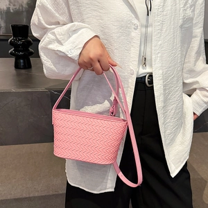 Detail of pink woven leather bucket bag with intricate Intrecciato texture and slim strap