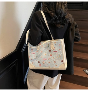 Sac fourre-tout à carreaux bleu clair avec motifs de dessins animés porté à l'épaule
