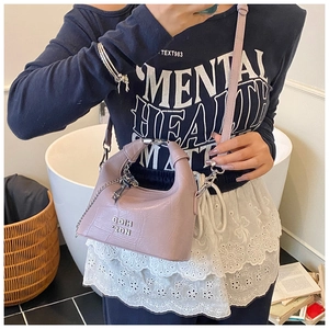 Lilac crocodile embossed mini crossbody bag shown on a model in a minimalist setting
