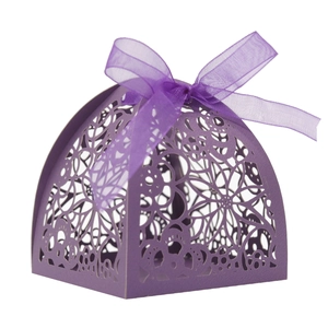 Macro detail of purple laser-cut candy box with intricate floral hollow pattern and ribbon