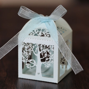 Macro detail of laser-cut tree and bird pattern on light blue candy gift box