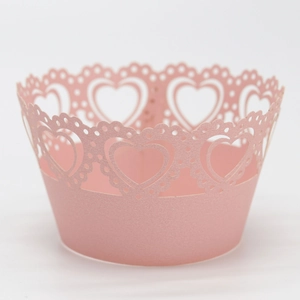 Detailed close-up of pink heart laser-cut cupcake wrappers for party dessert decoration