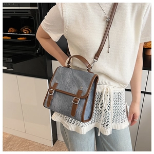 Detail of vintage grey-blue crossbody bag with brown leather trim and silver buckles
