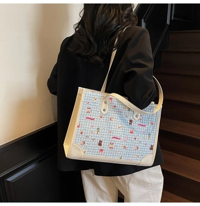 Vue détaillée du sac cabas à motifs d'ours avec finitions en cuir porté par un modèle