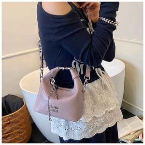 Detail of lavender croc-effect crescent bag with silver metal handle and chain charm