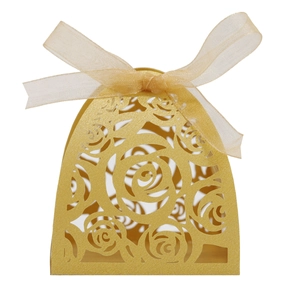 Close-up of golden laser-cut rose hollow candy box with an elegant organza ribbon bow