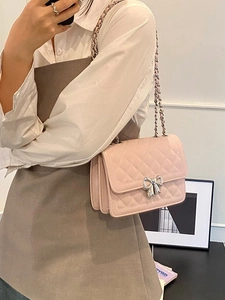 Sac bandoulière rose matelassé avec fermoir papillon argenté et bandoulière chaîne