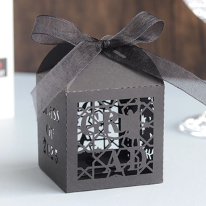 Elegant black laser-cut graduation favor box for 2025 class with a satin ribbon bow