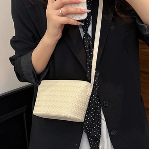 Cream woven leather mini crossbody bag detailed texture shown on a female model
