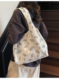 Large floral tote bag featuring grey koi fish print worn on shoulder for casual daily use