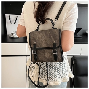 Detail of vintage grey backpack with rectangular flap and black handle shown on model