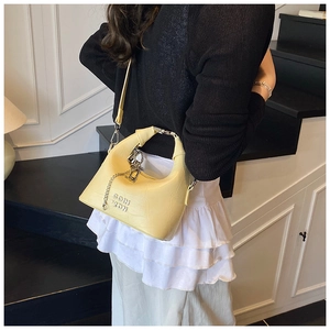 Detail of lemon yellow faux crocodile handbag with silver COTH 2DN metal hardware logo