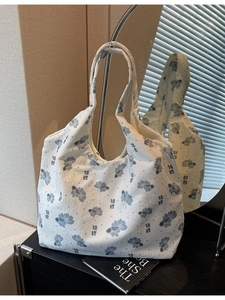 White canvas tote bag featuring blue koi fish print and wide shoulder straps in minimalist style