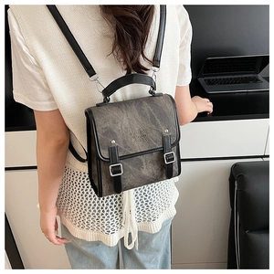 Retro grey backpack with vintage texture, dual straps, and silver buckles shown on model