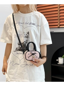 Borsa a tracolla rosa plissettata con fiocco nero e ciondolo a cuore in un outfit alla moda