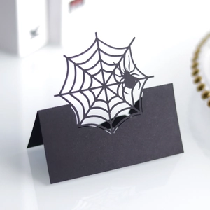 Detail of laser-cut black spider web place card for Halloween table setting decoration