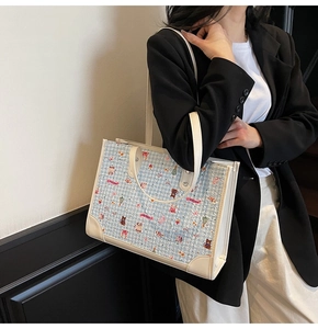 Détail du grand sac cabas à carreaux bleus avec illustrations et poignées en cuir