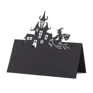 Laser-cut Halloween place card featuring a black haunted castle and flying witch silhouette