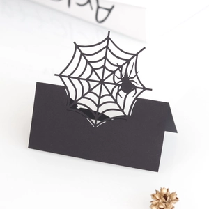 Detail of laser-cut black spider web place card for Halloween table setting