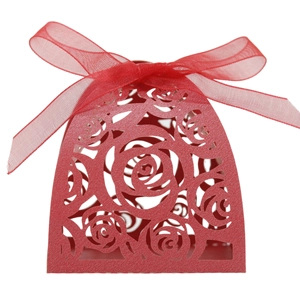 Detail of red laser-cut rose hollow favor box with elegant organza ribbon bow