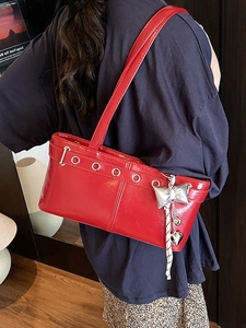 Borsa sottobraccio retrò rossa in pelle lucida con borchie e ciondolo a cuore su modella