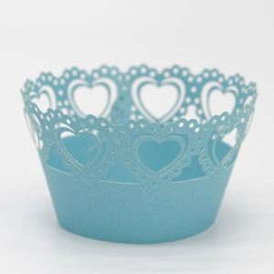 Macro detail of laser-cut heart patterns on light blue pearlescent cupcake wrappers
