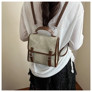 Close-up of vintage khaki canvas backpack with brown leather straps and metal buckles