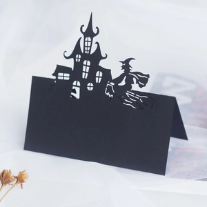 Detail of laser-cut black Halloween place card with witch and gothic castle silhouette