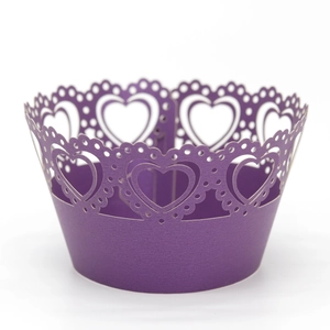 Macro detail of laser-cut heart pattern on a purple glitter cupcake wrapper for parties