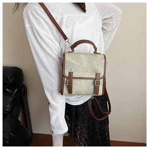 Detail of vintage mini messenger bag with enjoy chan text and brown trim on beige leather