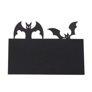 Detail of hollowed-out black paper bat place cards for Halloween table decoration