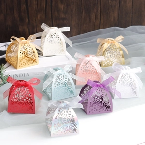 Detail of laser-cut floral candy boxes with ribbon bows in multiple elegant colors
