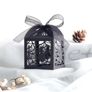 Detail of laser-cut black spider web candy box with a silk ribbon for Halloween