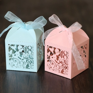 Close-up of laser-cut hollow 18th birthday candy boxes with elegant silk ribbons