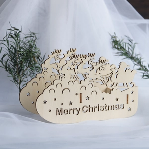 Close-up of laser-cut wooden Santa and reindeer sleigh Christmas ornament on soft fabric