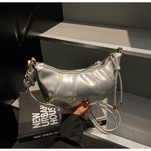 Detail of metallic silver pleated dumpling bag with leather texture and thin shoulder strap