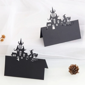 Macro detail of laser-cut black Halloween place card with witch and castle motifs