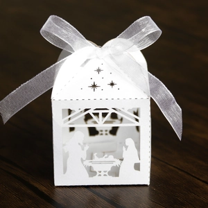 Detail of laser-cut white nativity scene candy box with white organza ribbon bow