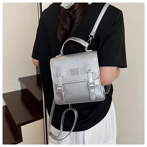 Silver metallic mini backpack detail showing textured leather and engraved enjoy lettering