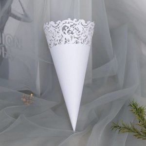 Detail of white laser-cut confetti cone with elegant lace pattern for wedding petals