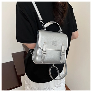 Rear view of a silver metallic vintage backpack on a model showing daily carrying size