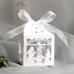 Detailed laser-cut nativity scene on white paper candy gift box with elegant satin ribbon