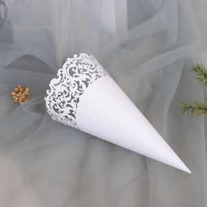 Detail of white laser-cut paper cone with intricate European lace patterns for weddings