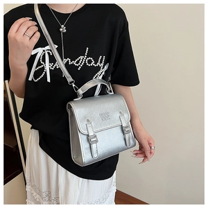 Silver metallic crossbody bag with buckle detail shown from a side-profile view