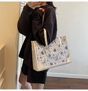 Détail du grand sac cabas avec motifs d'ours bleus et fleurs sur un tissu couleur crème