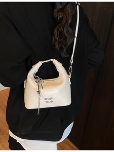 White faux crocodile skin crossbody handbag with gold chain detail and circular handle